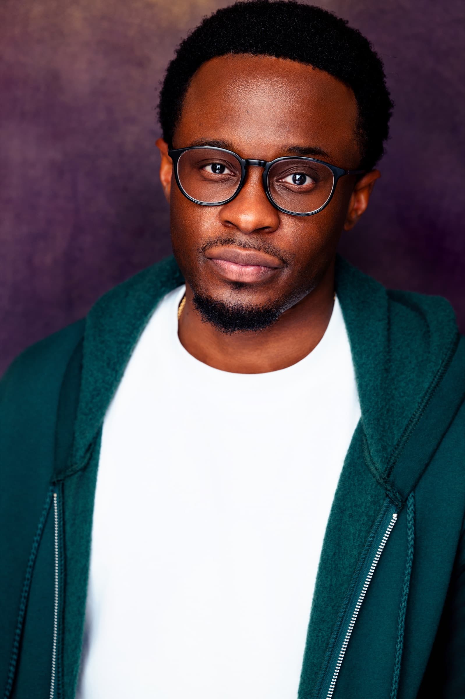 Lanre Adigun headshot — green hoodie